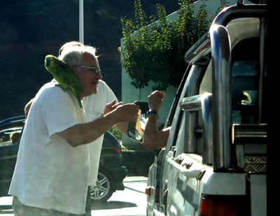 Man with a live parrot at the petrol station